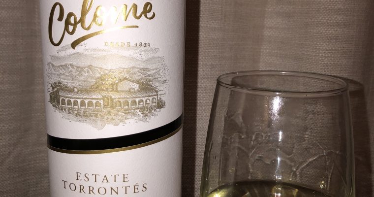 A half full bottle of Colome Estate Torrontes with a partially filled glass beside it.