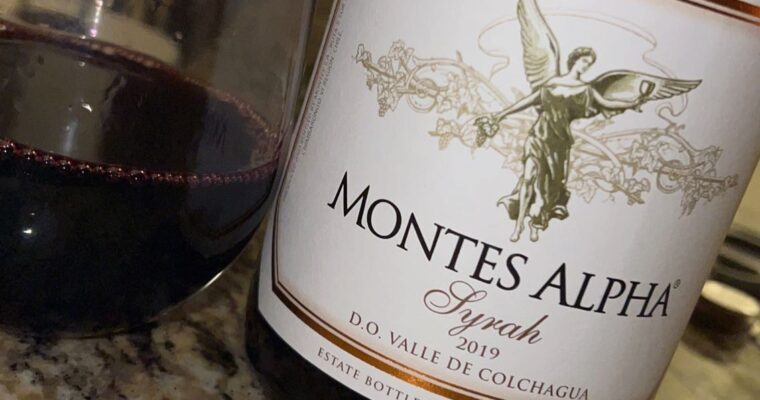 Bottle of Montes Alpha's Syrah and a glass of it next to the bottle.